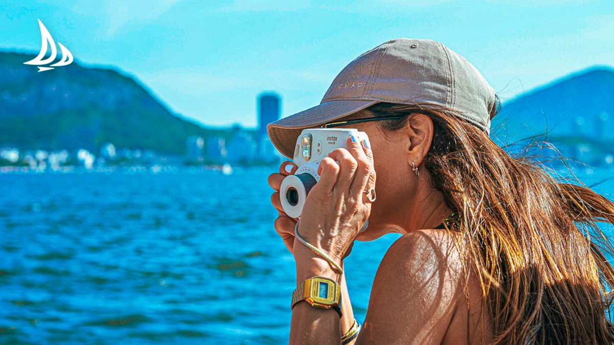 mulher no passeio de barco fotografando a paisagem do RJ