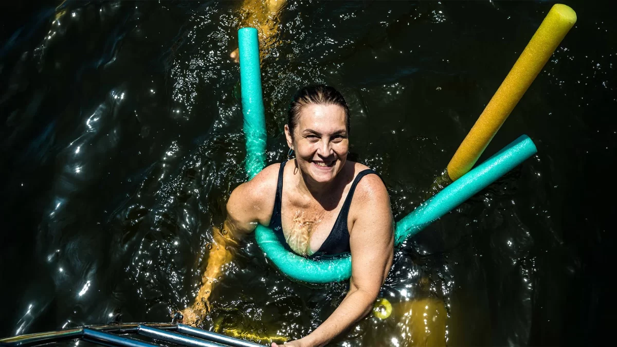 mulher com metade do corpo submerso no mar
