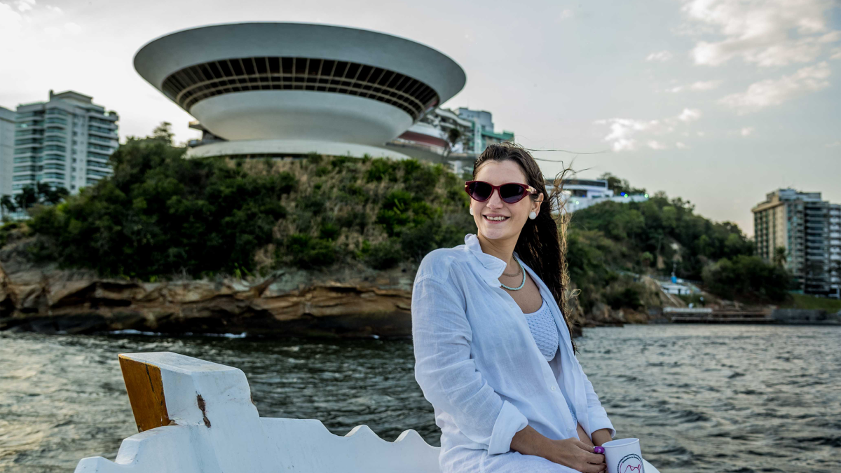 mulher-no-barco-da-ddrio-ao-fundo-museu-de-niteroi